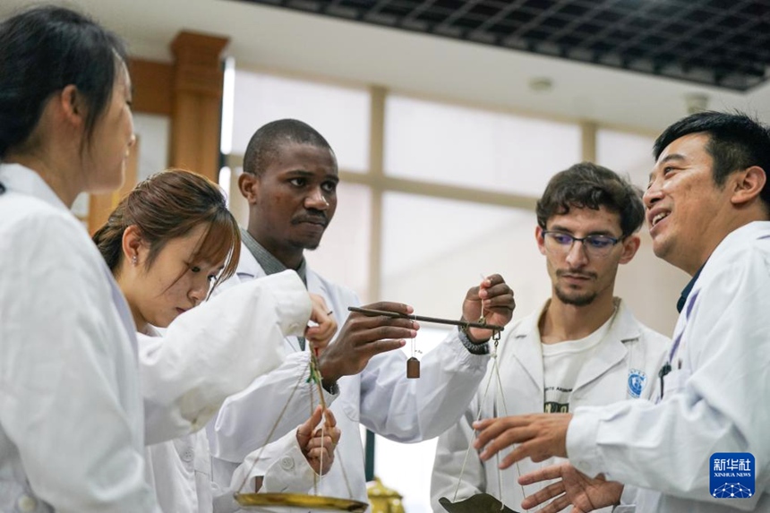 안후이중의약대학교 판인싱(潘銀星) 교수가 외국인 학생들에게 저울 사용법을 가르치고 있다. [10월 16일 촬영/사진 출처: 신화사]