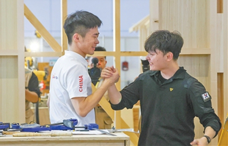 목공 종목 경기 후 중국 선수와 한국 선수가 손을 맞잡고 있다. [사진 출처: 인민망]